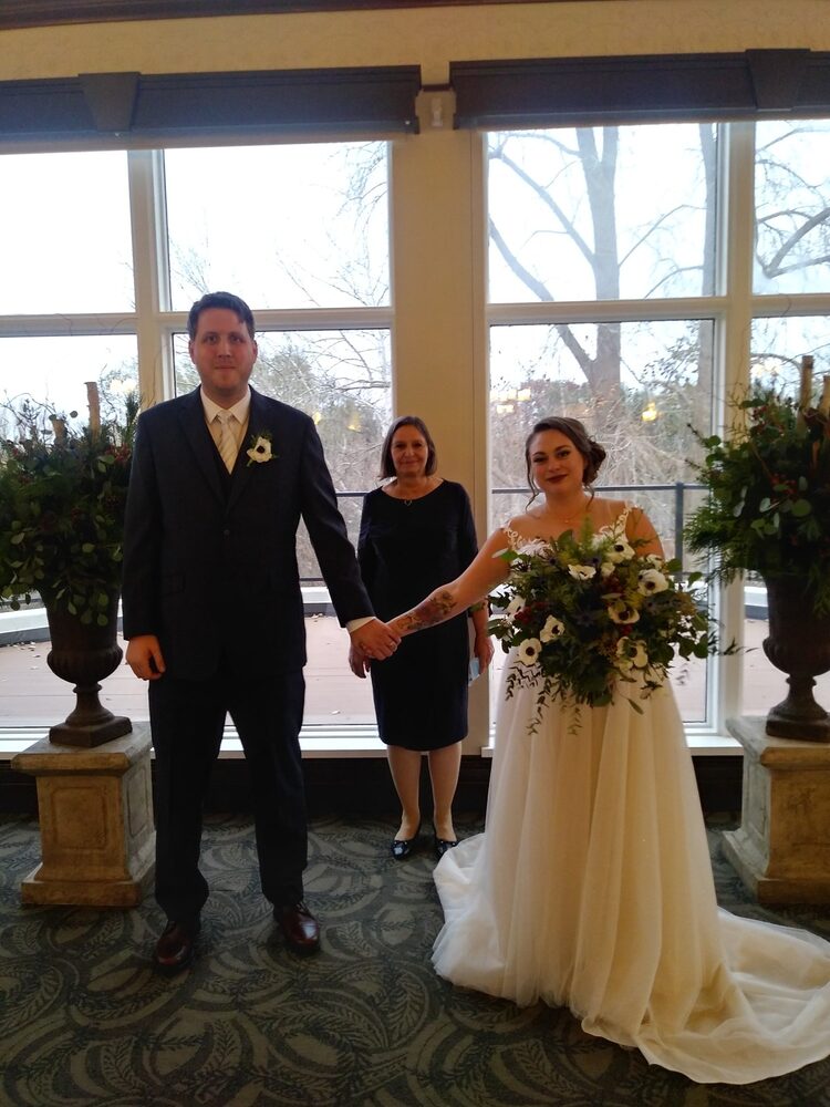 Debra with a couple after their indoor wedding ceremony
